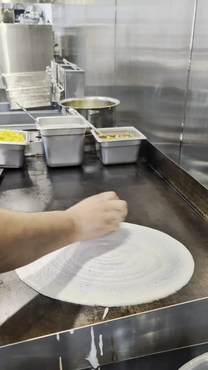 Dosa batter being spread on the tawa at Sitara